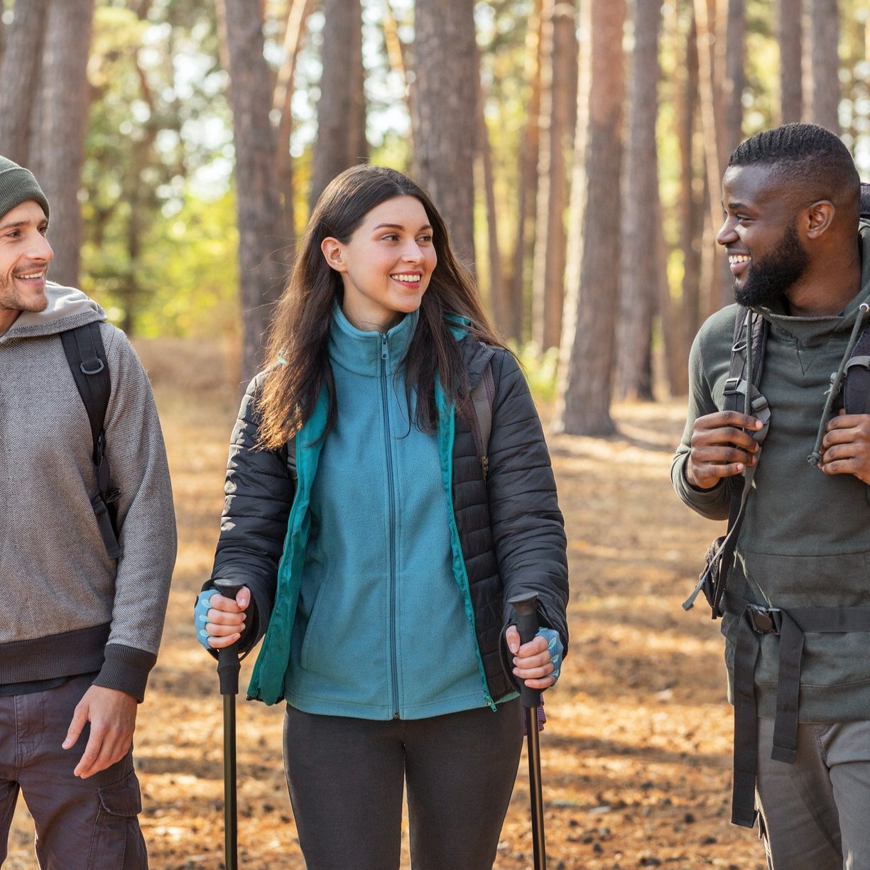 Multiracial group of hikers walking by forest